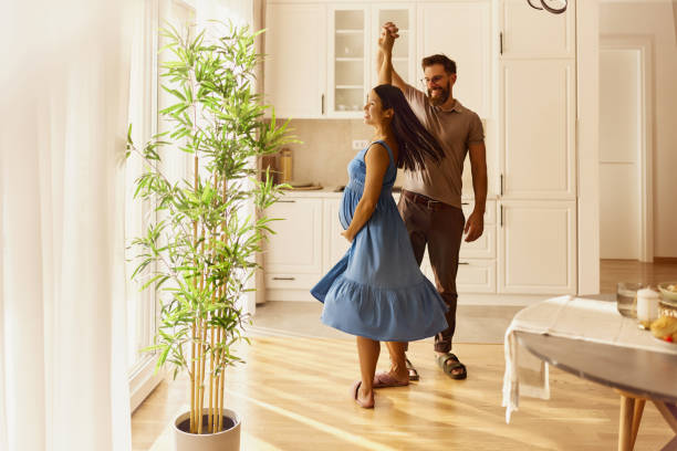 istock Carefree pregnant couple having fun while dancing at home. 2196143342