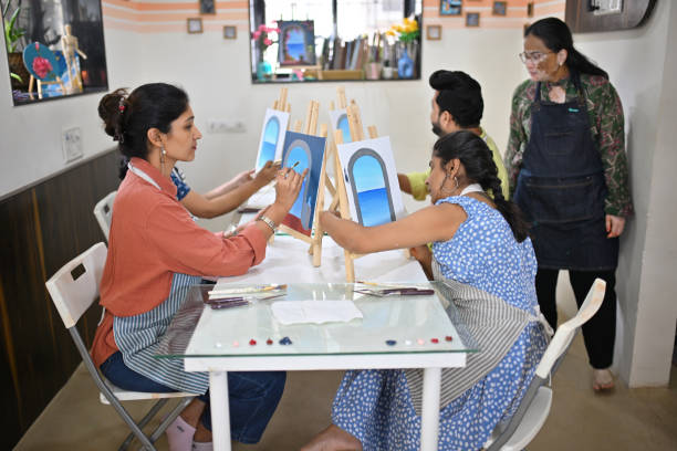 istock Passionate woman artisan observing participants during a canvas painting workshop 2196144369
