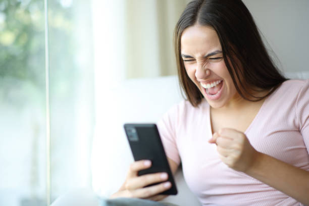 istock Excited woman checking phone at home 2196144375