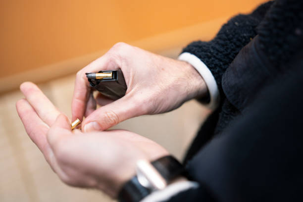 istock Close-up of hands carefully loading bullets into a magazine showcasing precision and tactical readiness 2196144715