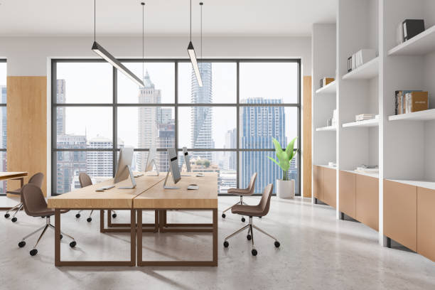 istock Modern open space office interior with wooden furniture and large windows overlooking a cityscape. 3D Rendering 2196144944