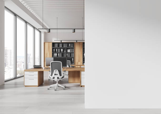 istock Modern office interior with wooden desks, white chairs, shelves, and large windows in an open loft-style space. 3D Rendering 2196145454