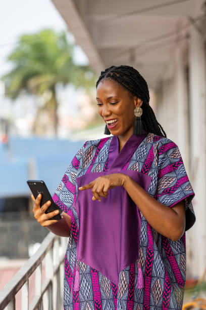 istock Happy African woman using her phone outdoors, smiling. 2196145932