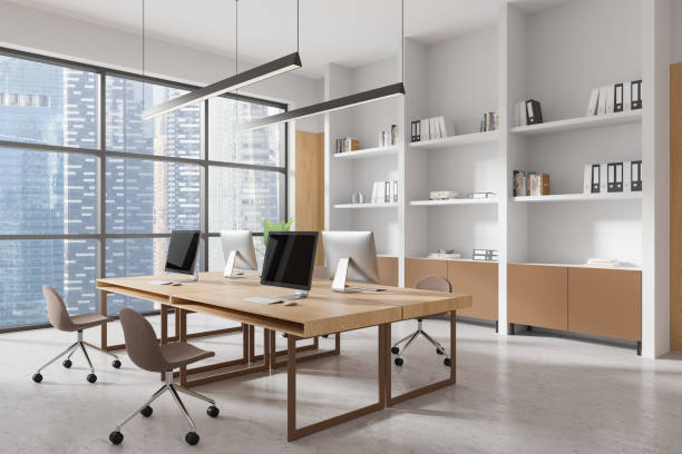 istock Modern office interior with wooden desks, chairs, and large windows overlooking a cityscape. 3D Rendering 2196145945