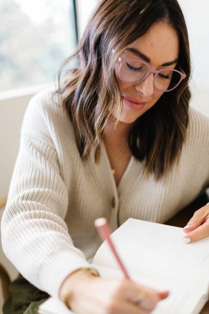 istock Young woman writing in a notebook with focus. 2196147176