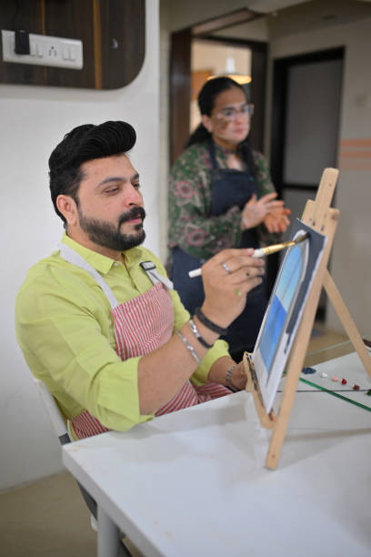 istock Mid-adult man enjoying his canvas painting during a creative workshop 2196148167