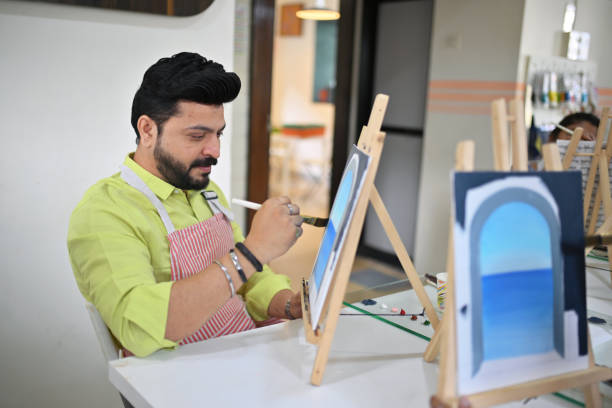istock Mid-adult man enjoying his canvas painting during a creative workshop 2196148168