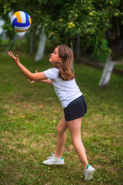istock Young girl playing volleyball in backyard during summer day 2196148960