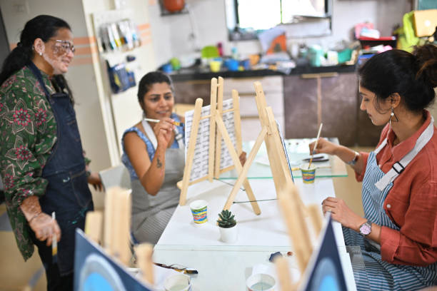 istock Skilled artisan teaching a woman during a canvas painting class 2196150478