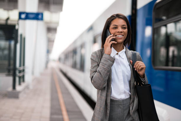 istock Young businesswoman talking on phone while walking on railway station 2196150874