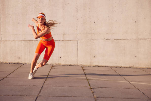 istock Skater exercise. Fit woman doing interval workout outdoors against concrete wall 2196151937
