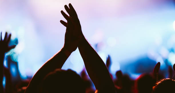 istock Crowd at concert. Stage lights and hands in the air. 2196152246