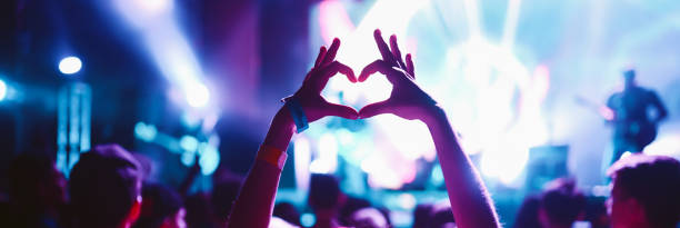 istock Crowd at concert. Stage lights and hands in the air. 2196152248