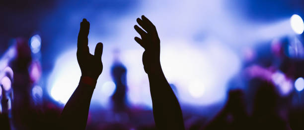 istock Crowd at concert. Stage lights and hands in the air. 2196152256