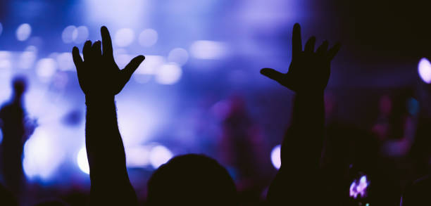 istock Crowd at concert. Stage lights and hands in the air. 2196152257