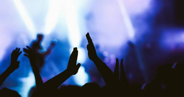 istock Crowd at concert. Stage lights and hands in the air. 2196152266