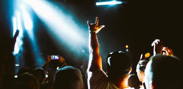 Crowd at concert. Stage lights and hands in the air. People enjoying the party. Fans enjoying music festival.