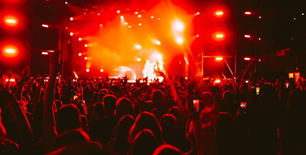 istock Crowd at concert. Stage lights and hands in the air. 2196152274