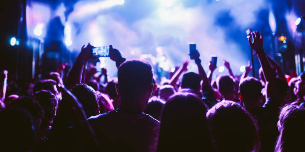 istock Crowd at concert. Stage lights and hands in the air. 2196152276
