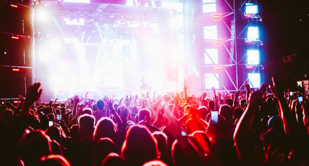 istock Crowd at concert. Stage lights and hands in the air. 2196152280