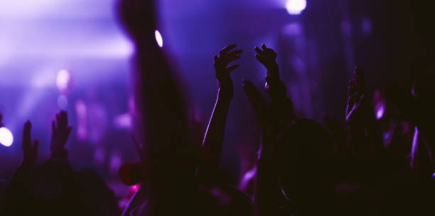istock Crowd at concert. Stage lights and hands in the air. 2196152282