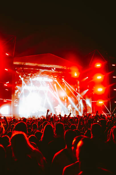 istock Crowd at concert. Stage lights and hands in the air. 2196152288