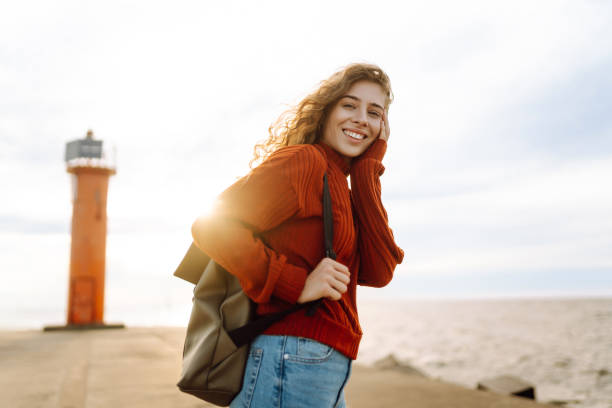 istock Young woman  looking toward lighthouse over sea. 2196153362
