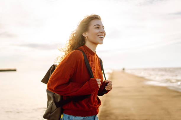 istock Young woman  looking toward lighthouse over sea. 2196153364