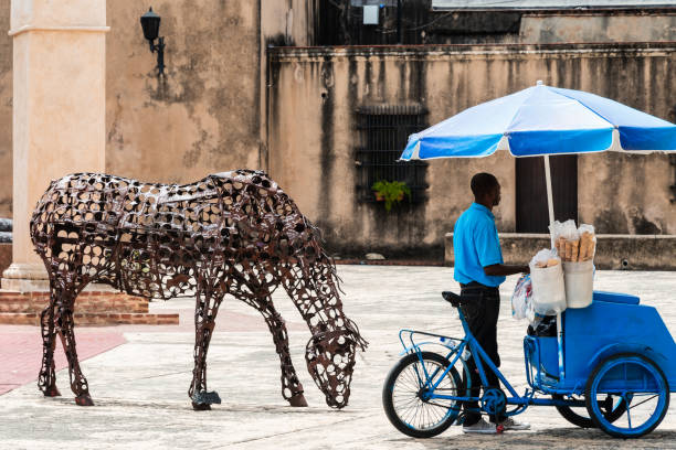 A street ice cream vendor at the Plazoleta del reloj and Fort Invincible (Santo Domingo-Dominican Republic) next to the Casa de los Dávila and the Chapel of Los Remedios.