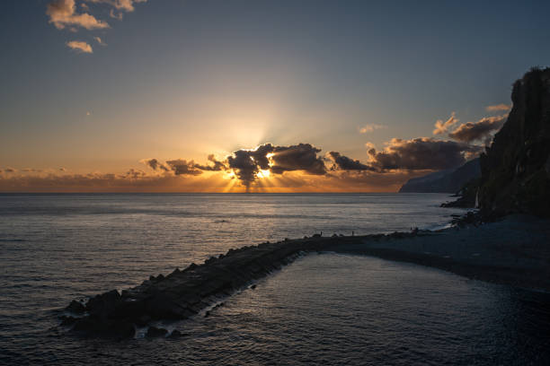 Atlantic ocean and sunset. Cloudy colorful sky. Coastal cliffs. Ponta do Sol, Madeira, Portugal.