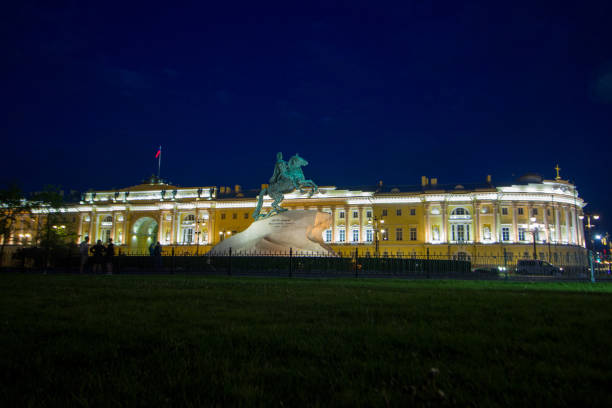 Female tourist of 48 years old is taking video standing on city square in cold night