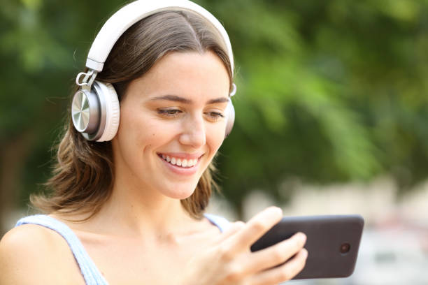 istock Happy woman watching media on cell phone in a park 2196158367