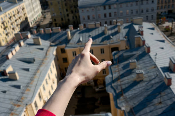 istock Hand pointing to the sky above a city 2196158929