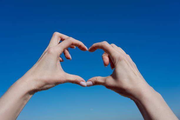 istock Two hands forming a heart shape in the sky 2196158934