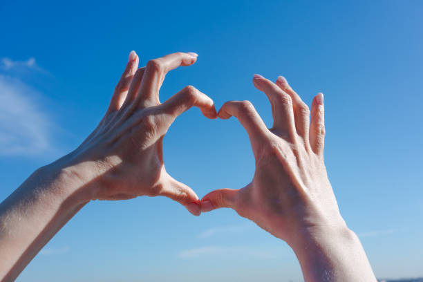 istock Two hands forming a heart shape in the sky 2196158935