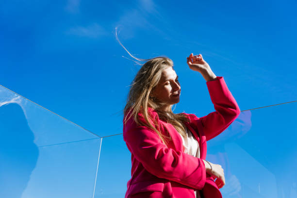 istock Woman in a red coat is standing outside on a clear day 2196158950