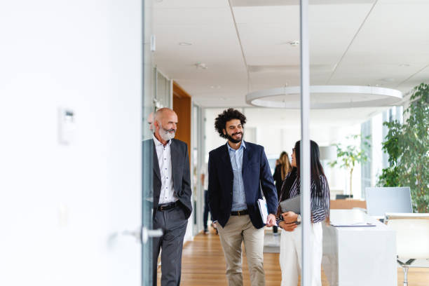 istock Business Professionals Walking in Office Corridor 2196159174