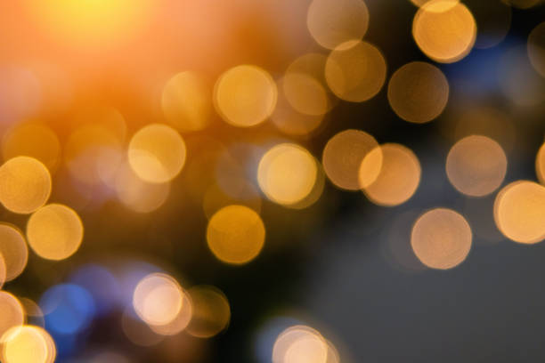 Blurred golden yellow bokeh on light gradient background. Abstract defocused blinking lights. Horizontal banner for text about holiday sales. Christmas and New Year.
