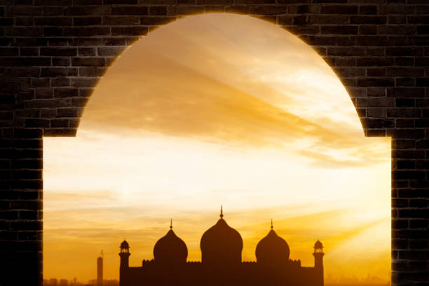 istock Sunrise View of Mosque Silhouette Framed by Brick Archway 2196160405