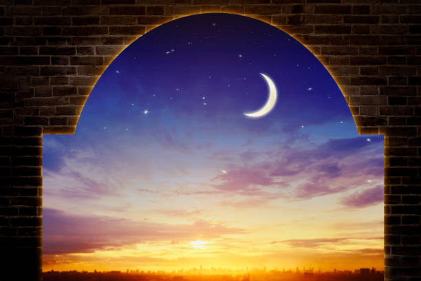 istock Night Sky with Crescent Moon Framed by Brick Arch and Cityscape at Sunrise 2196160410