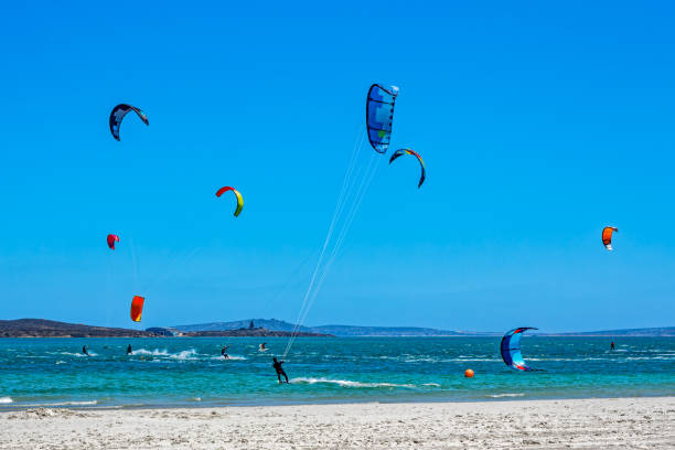 Kite surfers in bay with brightly coloured kites