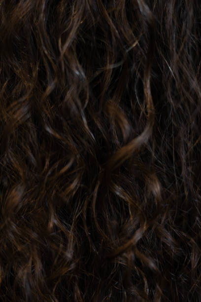 istock Natural wavy hair texture with rich dark tones enjoying light play 2196162617