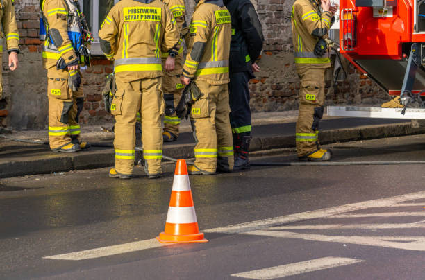 istock state fire brigade, firefighters standing on the street during a rescue and fire-fighting operation in an old tenement house. apartment fire. heavy fire truck and cones on the road. 2196163408