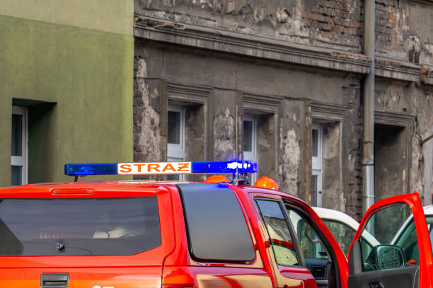istock Polish state fire brigade. command vehicle standing with a signal and blue lights against the background of a building. rescue and firefighting operation. 2196163435