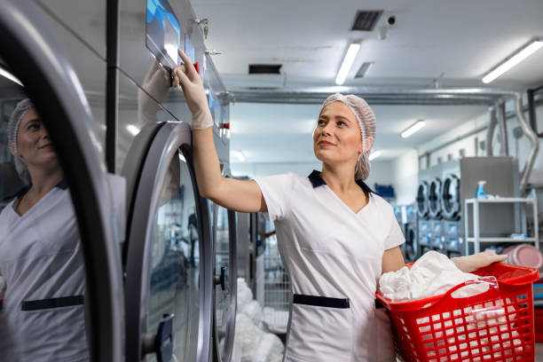 istock Female worker operating industrial washing machine in laundry service. 2196163706