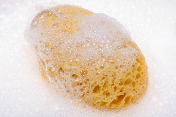White tiled shower with a loofah scrubber on a rope
