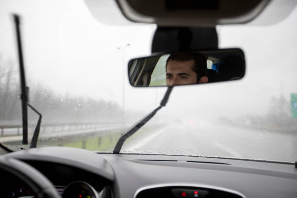 Young man driving carefully in the rain