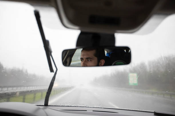 Young man driving carefully in the rain