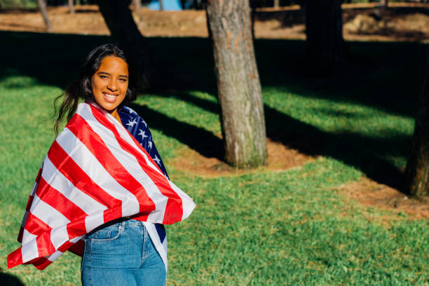 istock Smiling girl with American flag on shoulders, walking . 2196169400