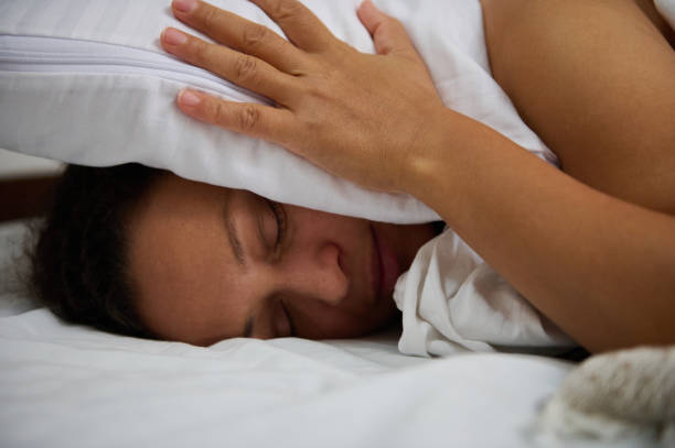 istock Woman sleeping soundly holding a pillow on a comfortable bed 2196170243
